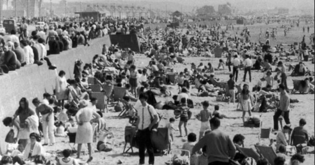 A black and white image of a crowded beach