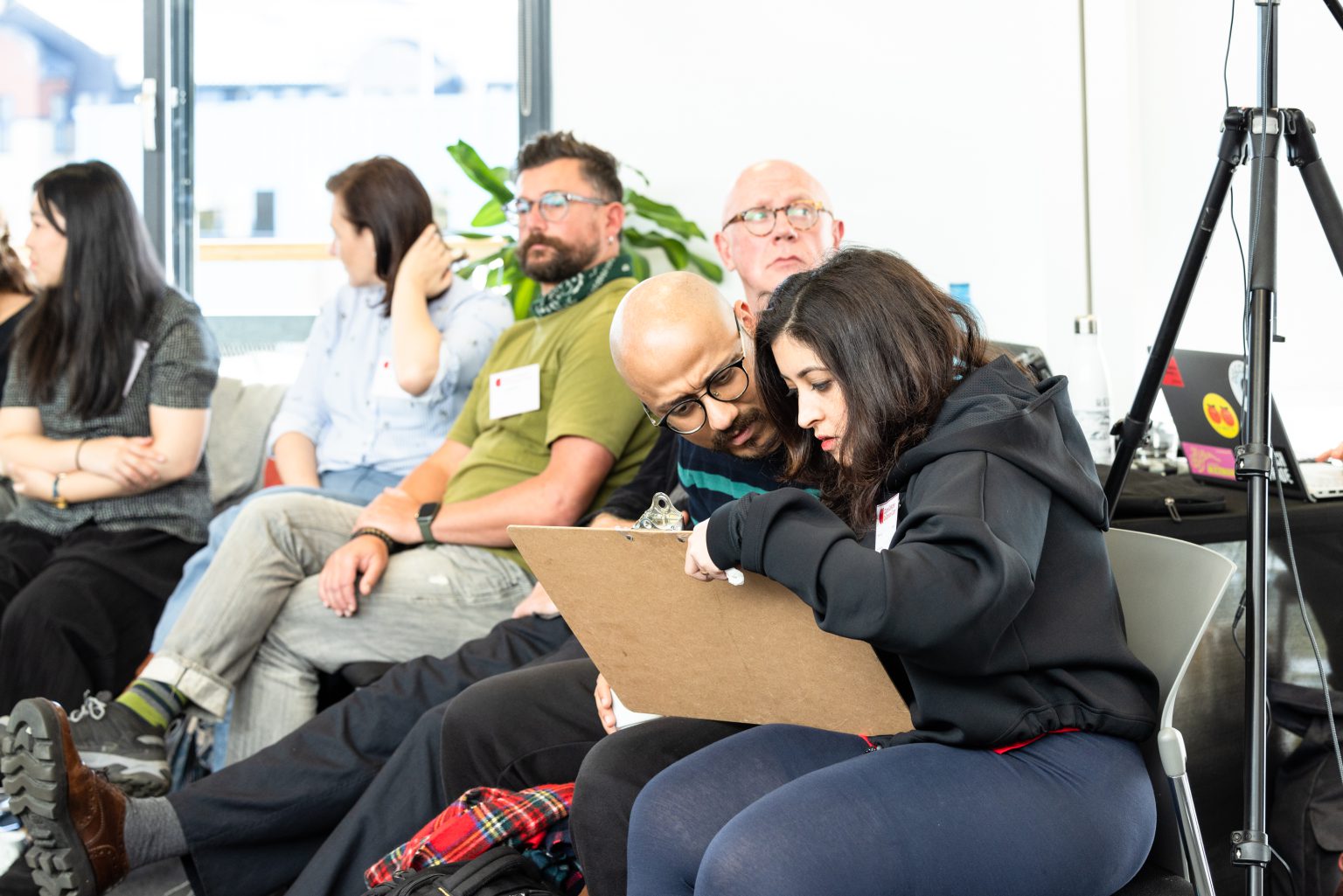 Two events participants look thoughtfully as they write