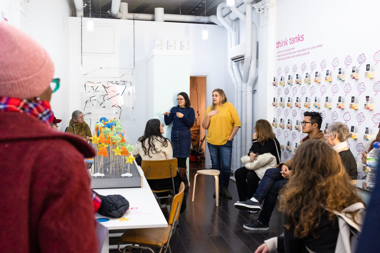 Some participants stand, whilst others sit, talking to one another.